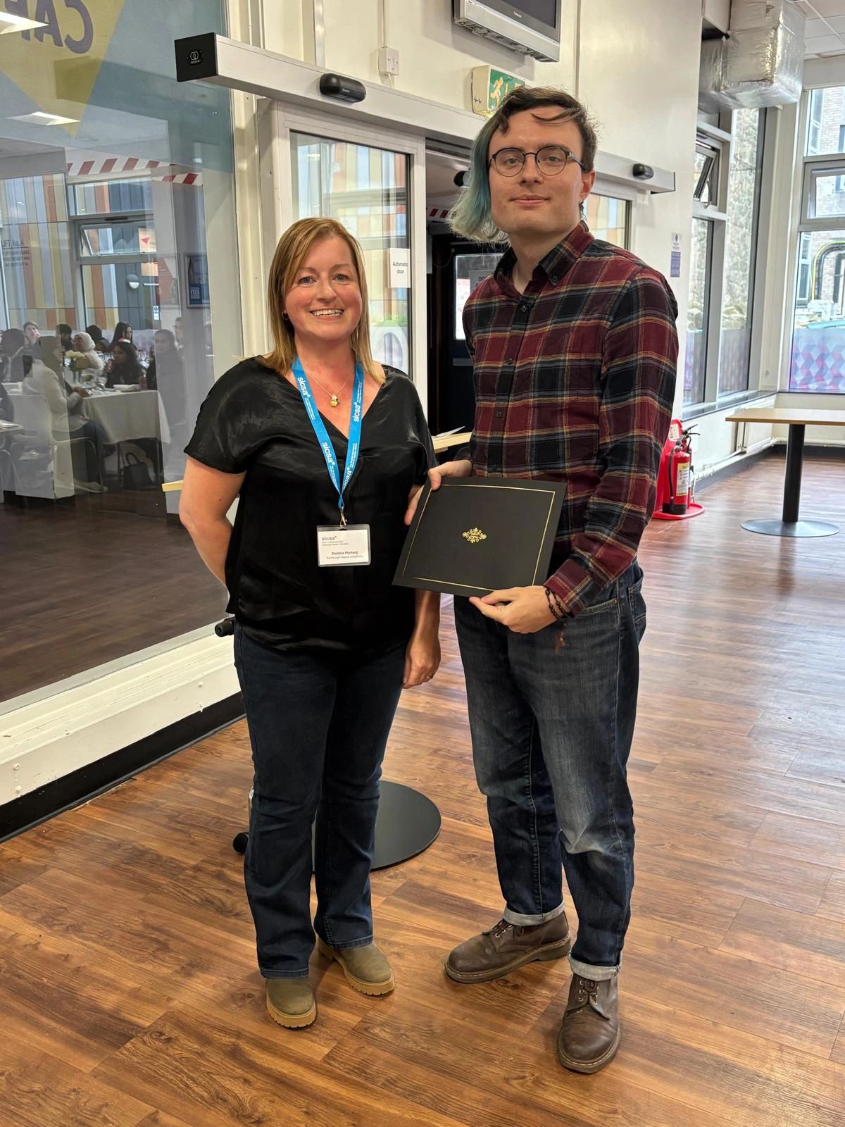 Gregor receiving the award from SICSA's Director of Education, Debbie Meharg